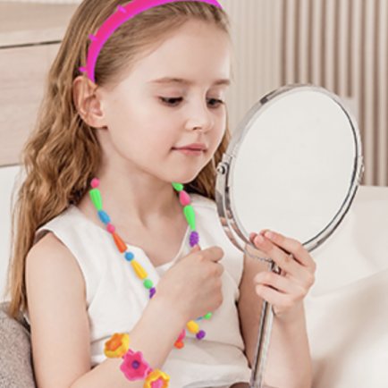 Girl admiring her Orian pop beads headband in a hand mirror